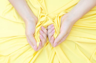 Çıplak manikür ile Kadın eller sarı bir bez tutun. 