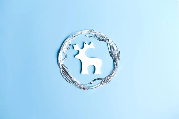 Figura decorativa de un ciervo en un círculo de lentejuelas sobre un fondo azul . —  Fotos de Stock
