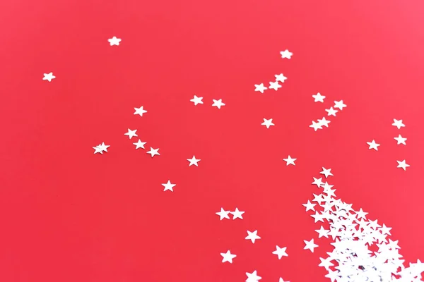Confettis étoiles argentées sur fond rouge . — Photo