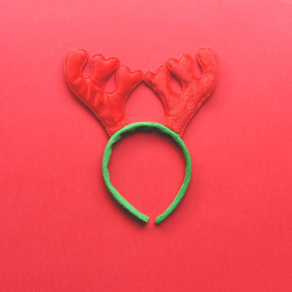 Christmas accessory in the form of a deer horn on a red background. 
