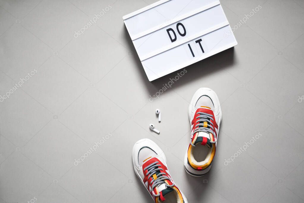 Sneakers, headphones and a sign saying do it.