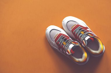 Turuncu arka planda çok renkli moda ayakkabıları.. 