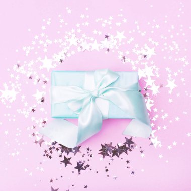 Pembe arka planda büyük bir nane renginde bir hediye ile düz yatıyordu.. 