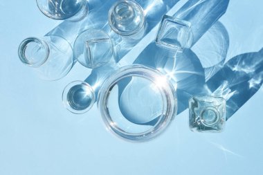 Çeşitli cam kaplar ve su ile minimal arka plan. Modaya uygun sert gölge..