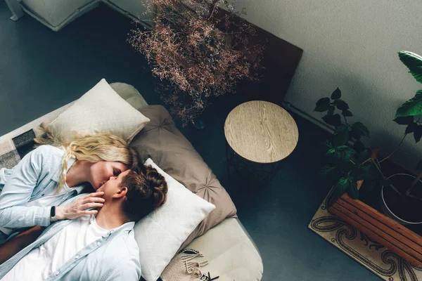 一对年轻夫妇躺在床上接吻 图库照片