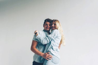 Beyaz bir duvarın yanında sarılan bir çift sevgili. İlişki. Aşk.