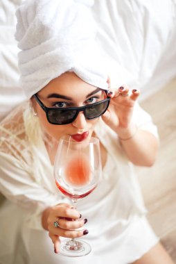 Kafasında havluyla güzel bir kız şarap içiyor.. 