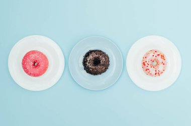 Mavi arka planda tabakta farklı parlak çörekler. Tatlı ve lezzetli yemekler..