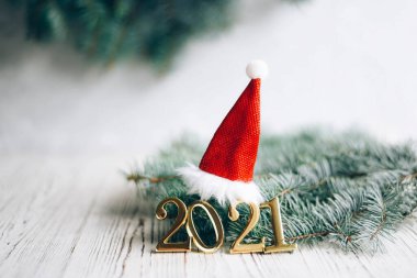Noel Baba şapkası ve Noel ağacı dallarıyla 2021 yılbaşı. Yeni yıl arkaplanı.