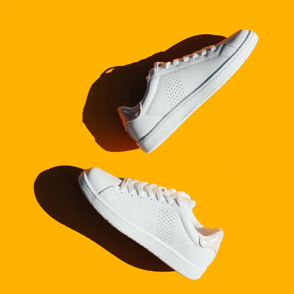 Sapatilhas Brancas Fundo Laranja Com Sombras Duras Sapatos Esportivos Elegantes — Fotografia de Stock