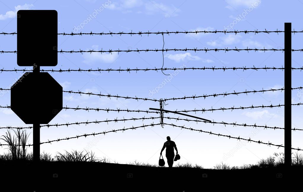 A man is seen in silhouette after breaching a border fence on the southern border of the USA.