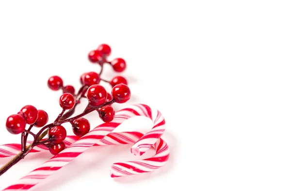 Bastones de caramelo de Navidad con una rama de bayas decorativas . — Foto de Stock