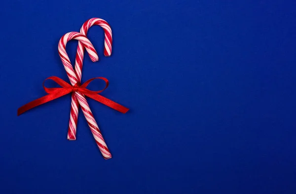Bastones de caramelo de Navidad sobre fondo azul. — Foto de Stock