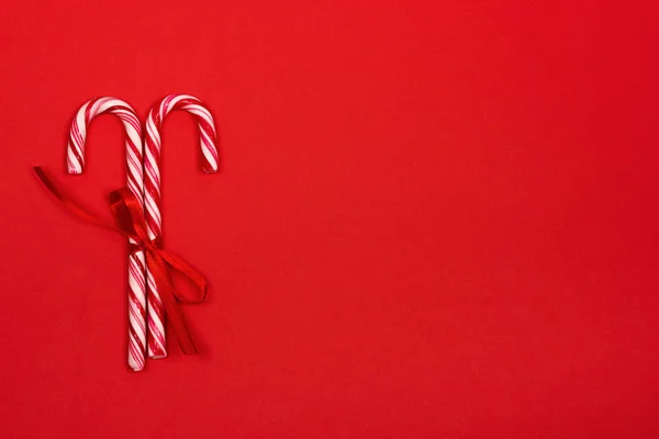 Bastones de caramelo de Navidad sobre fondo rojo . — Foto de Stock
