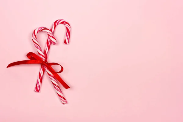 Bastones de caramelo de Navidad sobre fondo rosa . — Foto de Stock