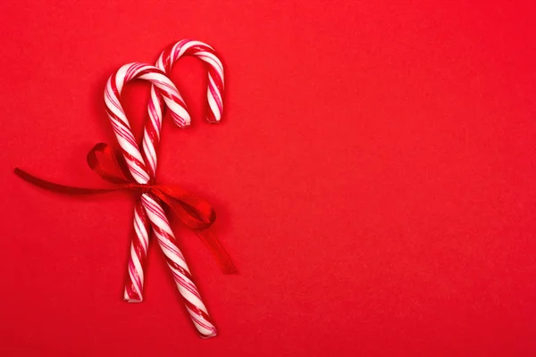 Bastones de caramelo de Navidad sobre fondo rojo . — Foto de Stock