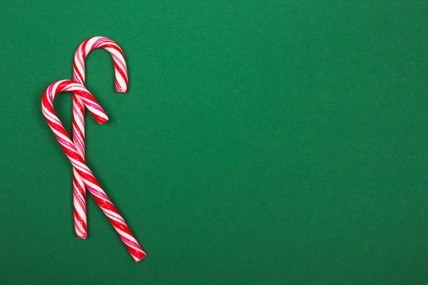 Bastones de caramelo de Navidad sobre fondo verde . — Foto de Stock