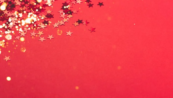 Metallic confetti on festive red paper background. — Stock Photo, Image