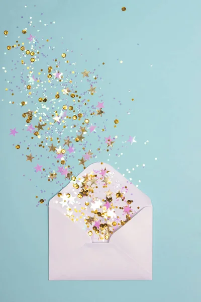 Gouden en roze confetti verspreid van de envelop op pastel mint achtergrond. — Stockfoto