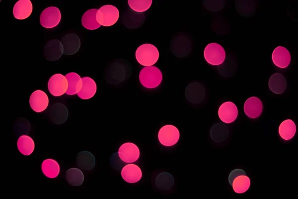 Abstracte magenta bokeh textuur op zwarte achtergrond. — Stockfoto