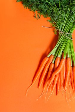 Demet taze çiğ havuç turuncu zemin üzerine.