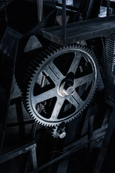 Huge illuminated gearwheel in old factory. Royalty free stock photo.