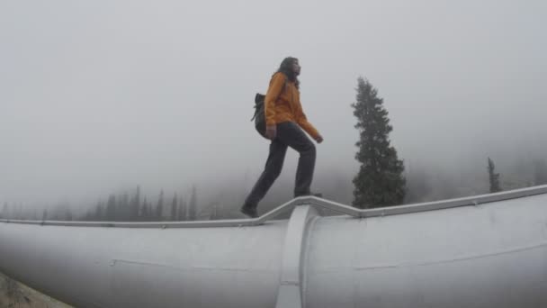 Ten chlap prochází trubkou vysoko v horách — Stock video