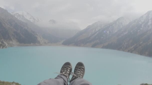 Füße baumeln im Wind über dem See — Stockvideo