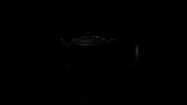 Eine Teekanne aus teurem Ton in einem Lichtstrahl — Stockvideo