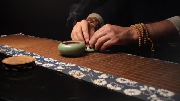 Master of tea ceremonies puts a container with incense — Stock Video