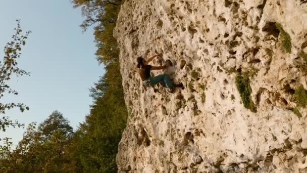 En bergsbestigare klättrar en kategori 5 rutt längs en klippa — Stockvideo