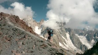 Bir adam yokuş yukarı gider, Ushba fonunda