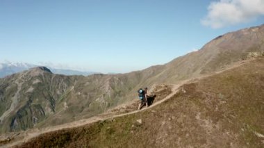 Güzel manzaralar arasında yokuş yukarı yürüyen bir adam.