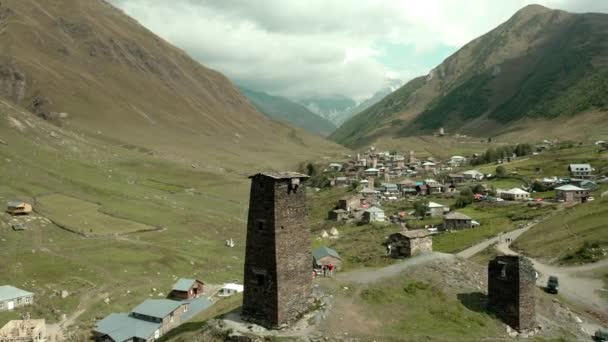 Oude torens in het dorp Ushguli op de achtergrond van met sneeuw bedekte bergen van Shkhara — Stockvideo