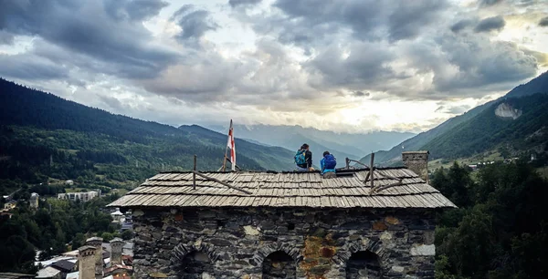 Chvanetia, Gürcistan. Çatıda oturan bir kız olan bir adam. 