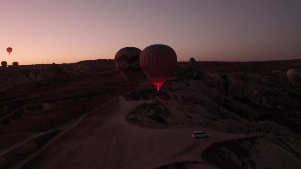 Un drone volant au-dessus des couilles tôt le matin. Des ballons survolent la Cappadoce — Video