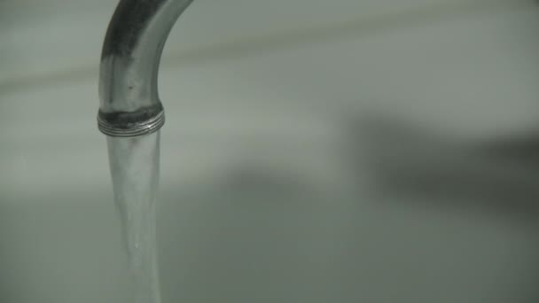 L'eau coule du robinet dans la salle de bain 