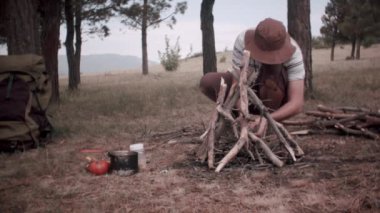 Turist doğada şenlik ateşi yakıyor.