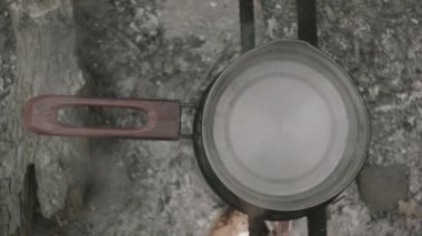 Bir tencere ateşte, su kaynıyor.