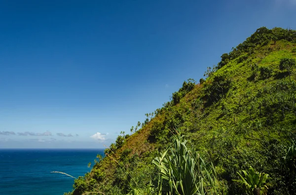 Verde colina abrupta frente al gran mar azul en Hawaii, EE.UU. — Foto de Stock