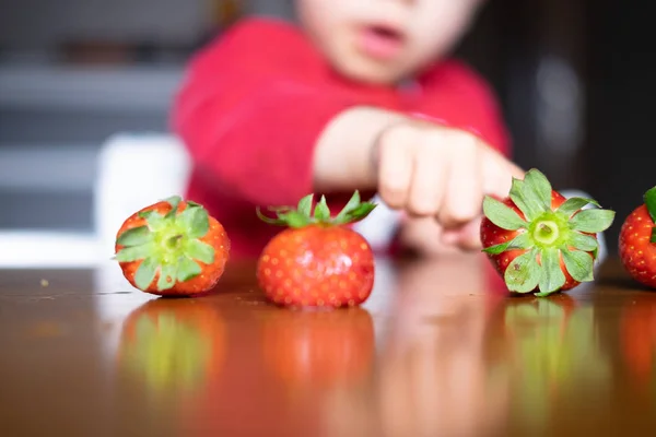 Baby s hand manipulating different fruits on a wooden table — Stock Photo, Image