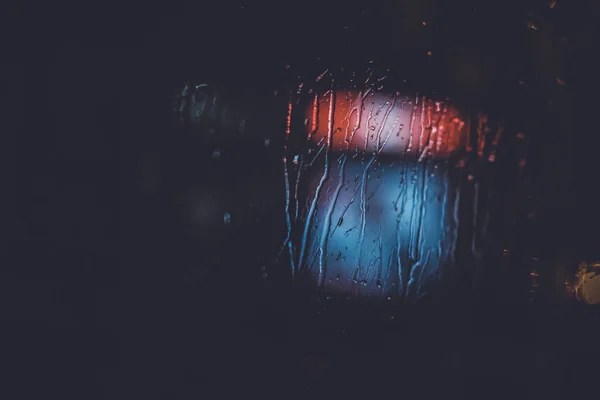 Traffic lights through the window in a rainy night — Stock Photo, Image