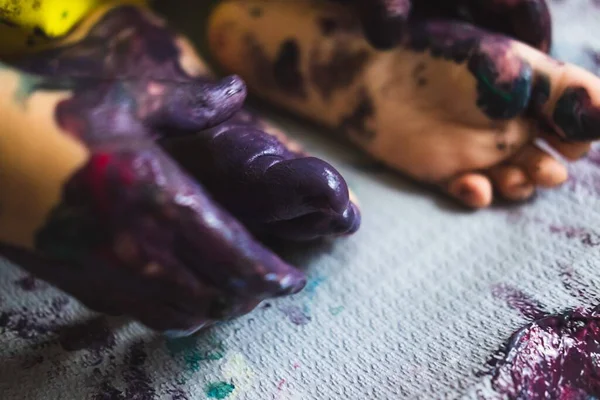 Pequeño niño manos y pies cubiertos de múltiples colores — Foto de Stock