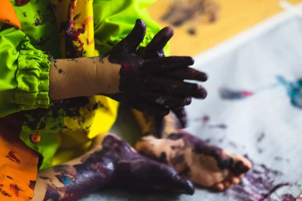 Pequeño niño manos y pies cubiertos de múltiples colores — Foto de Stock