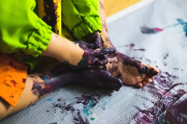 Pequeño niño manos y pies cubiertos de múltiples colores — Foto de Stock