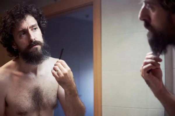 Középkorú spanyol férfi vágja a szakállát. — Stock Fotó