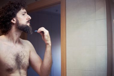 Orta yaşlı İspanyol adam sakalını kesiyor.