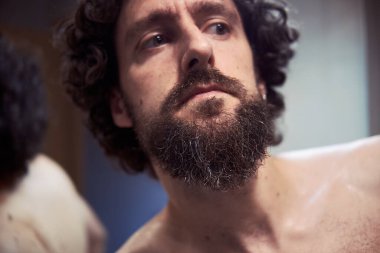 Orta yaşlı İspanyol adam sakalını kesiyor.