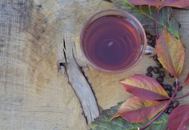 Yaprakları ve bardak çay ahşap zemin ile sonbahar kompozisyon.