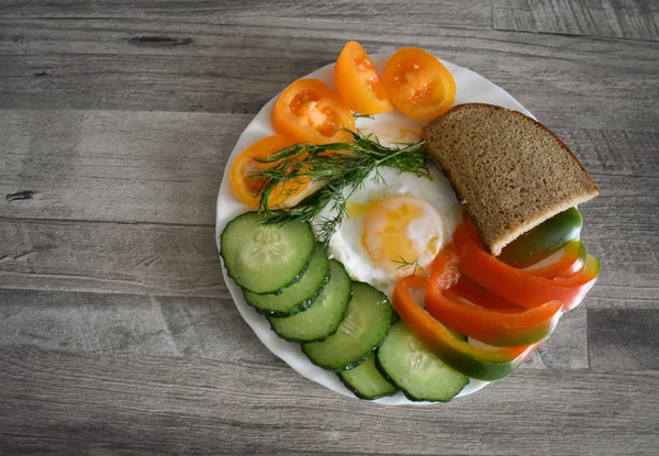 Dish with food on a textured Board. Eggs decorated with vegetables.